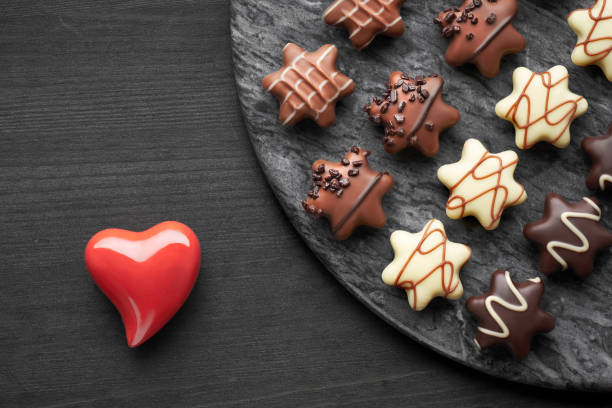 istock Star-shaped chocolates on dark textured background with red ceramic heari 1087610258
