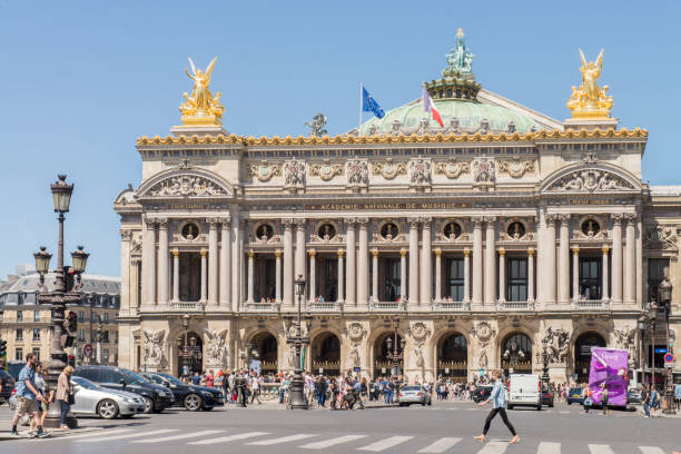 People walking in the Place de l´opera (Opera square) next to the Palais Garnier Opera House (Opera du Paris) at Paris city, France. People walking in the Place de l´opera (Opera square) next to the Palais Garnier Opera House (Opera du Paris) at Paris city, France. Inaugurated in 1875, it is one of the most famous places in Paris. place de lopera stock pictures, royalty-free photos & images