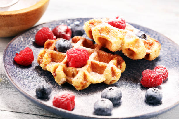 istock waffles with fresh blueberries, sugar and raspberries. 1087614566