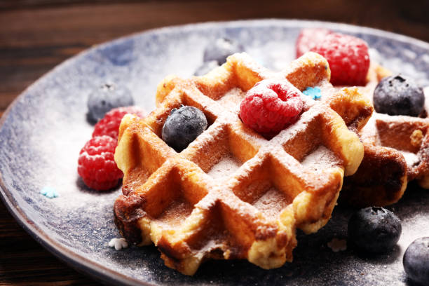 istock waffles with fresh blueberries, sugar and raspberries. 1087615302
