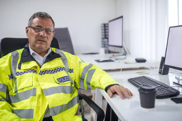 istock British police officer sitting at the office 1087621146