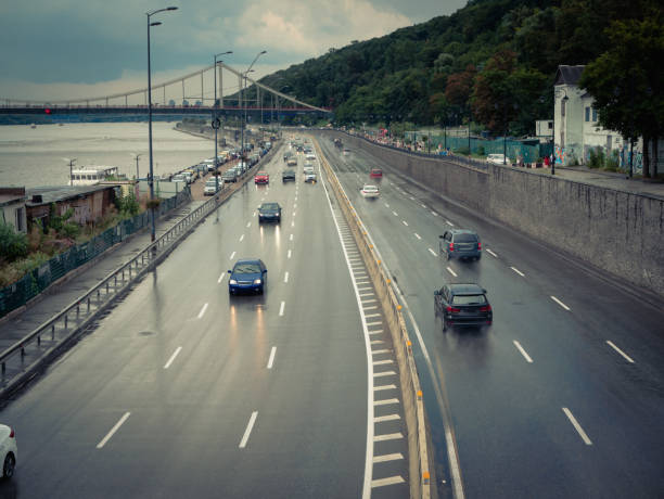 view at city wet highway road with driven cars from above. cloudy weather summer outdoor image