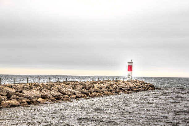 istock lighthouse at the end of a pier 1087624426