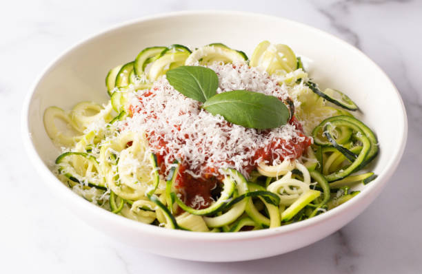 Zucchini Pasta Topped with Parmesean Cheese and Tomato Sauce Zucchini Pasta Topped with Parmesean Cheese and Tomato Sauce courgette stock pictures, royalty-free photos & images