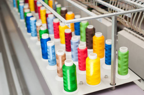 istock Multicolored skeins of thread on sewing machines 1087636638