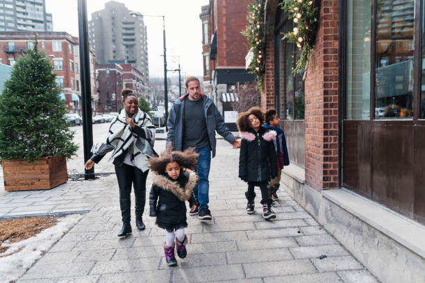 смешанные гонки семьи покупки на городской улице в зимний период. - city street montreal street city стоковые фото и изображения