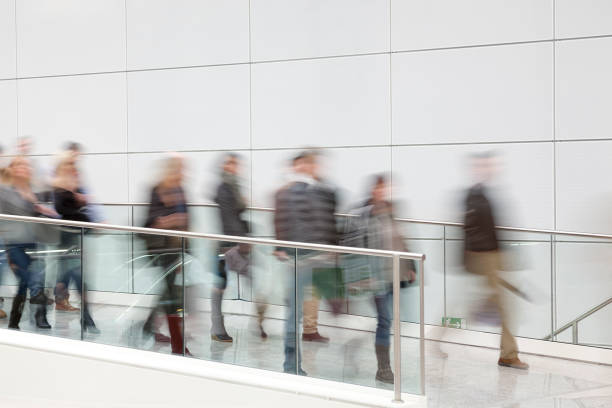 istock Group of People Walking Through The White Hallway 1087642358