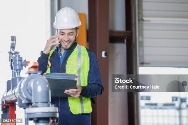 Engineer Working In Oil And Gas Industry Inspecting Pipeline Equipment On Job Site Stock Photo - Download Image Now
