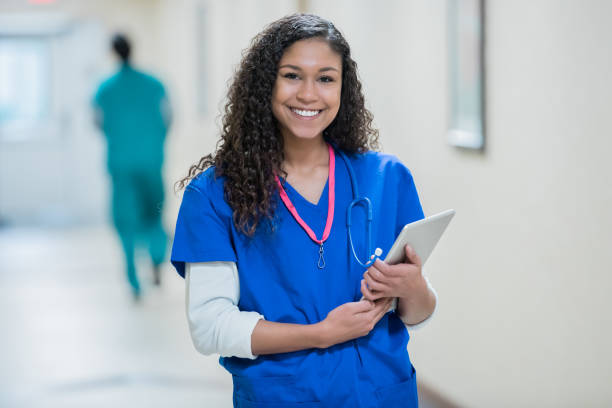 istock Young nurse in hospital hallway holding digital tablet patient chart 1087655846