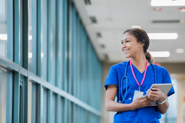 행복 한 병원 하늘에 걷고 있는 동안 젊은 간호사 미소 도보 이동 중. - computer medical student hospital nurse 뉴스 사진 이미지