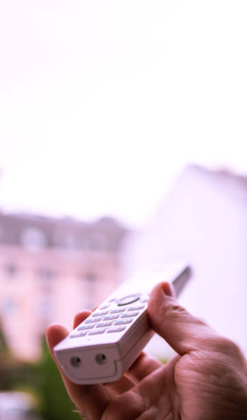 istock Man hand holding cordless phone calling home office 1087666844