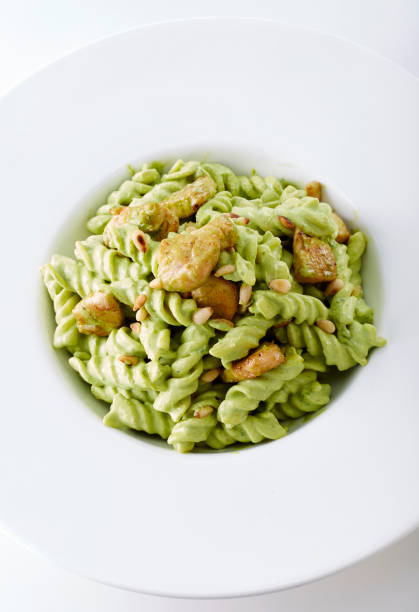 istock Delicious meat with green sauce pasta, on white background 1087671542