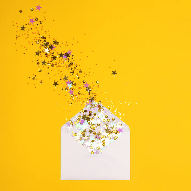 istock Colorful confetti scattered from envelope on yellow background. 1087671596