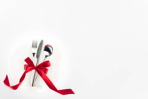 istock elevated view of fork, knife and spoon wrapped by red festive bow on plate isolated on white, st valentine day concept 1087678498