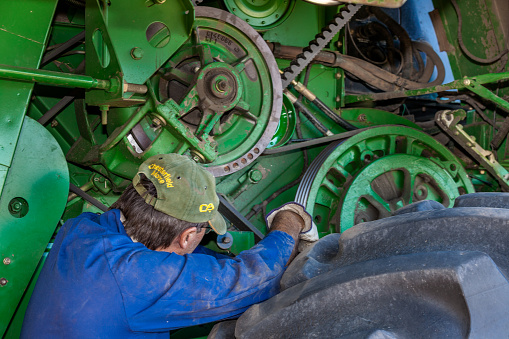 Moree, Australia - November 25, 2010: A farmer performs a maintenance routine on his John Deere combine harvester in Moree a major agricultural area in New South Wales, Australia.