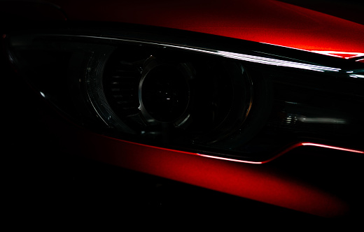 Closeup linterna de lujo rojo brillante SUV compacto coche. Concepto de automóvil eléctrico elegante de tecnología y negocios. Auto híbrido y concepto automotriz. Coche aparcado en la sala de exposición o demostración de motor. Concesionario de autom photo