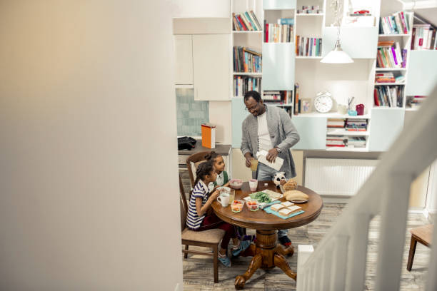 istock Beautiful twins having delicious breakfast with their father 1087718692