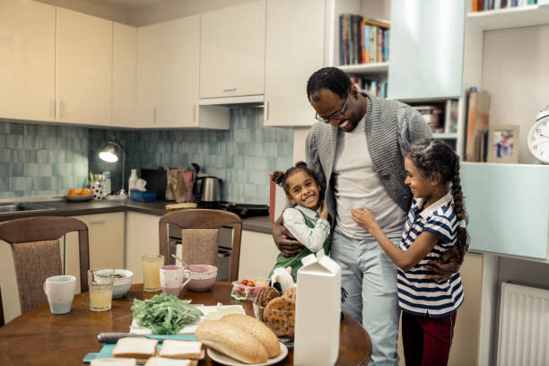 istock Cute twins feeling lovely while meeting father in the kitchen 1087718698