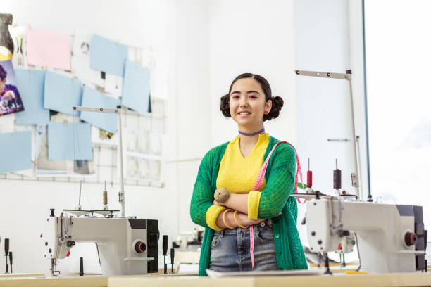 istock Young dark-haired asian designer in a green cardigan feeling great 1087729002