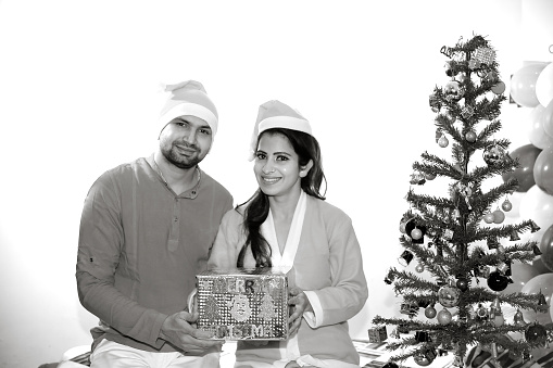Young couple with a gift on Merry Christmas.