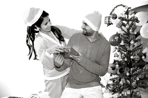 Young couple with a gift on Merry Christmas.