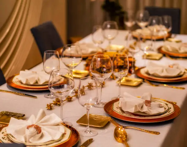 Festive table decorated with gold colored plates and cutlery