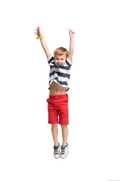 istock Adorable boy jumping and raises his hands up. 1087756254