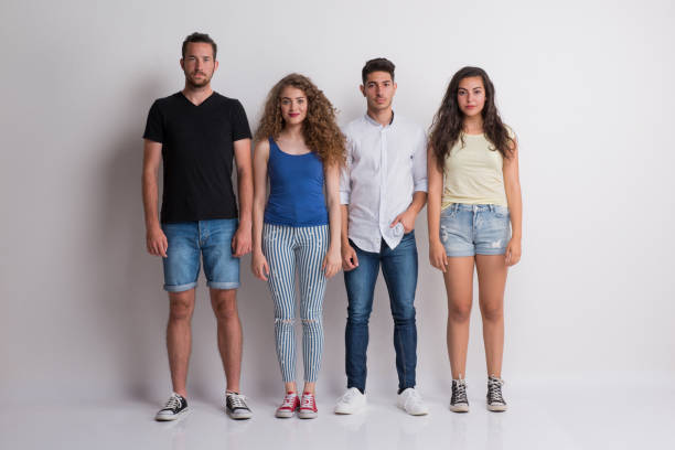 istock Joyful young group of friends standing in a studio, looking at camera. 1087772050