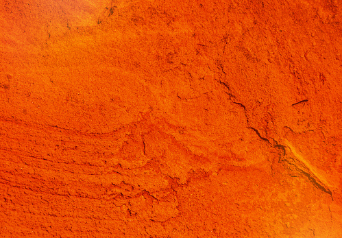 closeup on natural texture of a cracked red ocher wall
