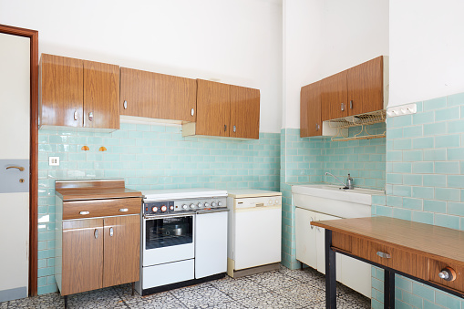 Old kitchen interior with turquoise tiles in old house in Italy
