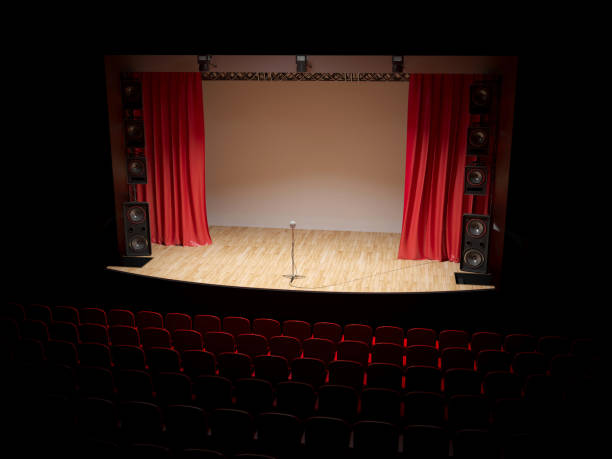 istock Concert hall with a red curtain and a microphone on the counter. 1087781806