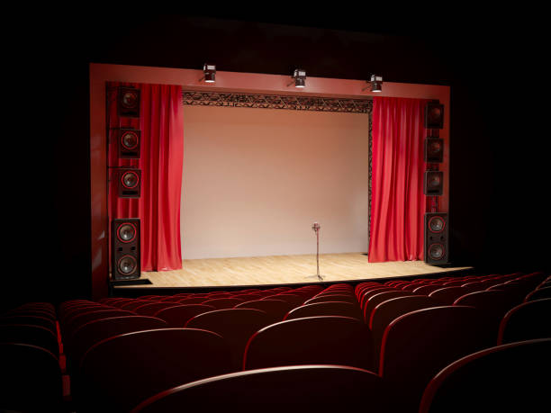 istock Concert hall with a red curtain and a microphone on the counter. 1087781812