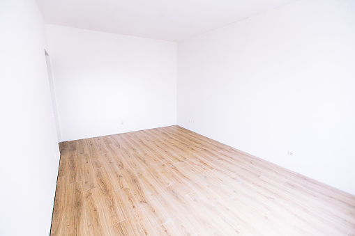 Photo of a white empty scandinavian room interior with wooden floor and walls. Home nordic interior.