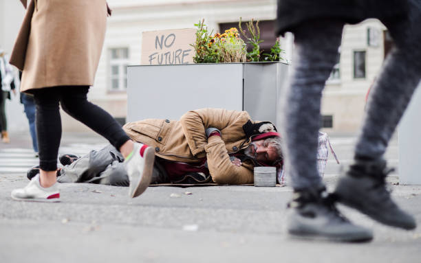 istock Homeless beggar man lying on the ground outdoors in city, sleeping. 1087788004