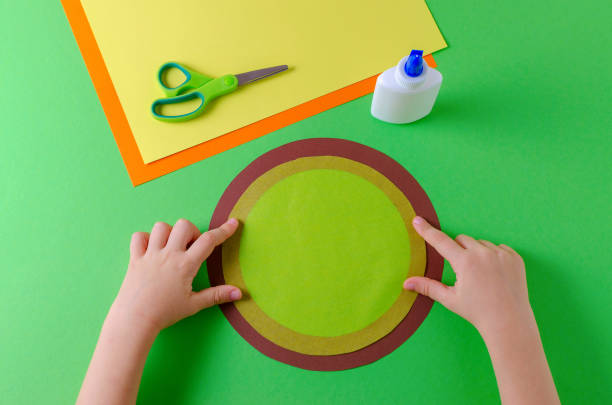 istock child glues two circles with color paper, glue and scissors 1087790164