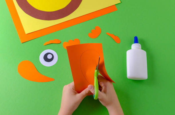 istock child cuts paper figure, view from above, glue and scissors on green 1087794432