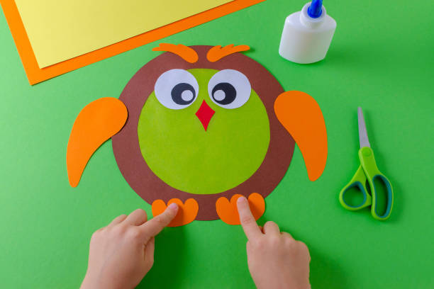 istock kid is making a owl with color paper, glue and scissors 1087797580