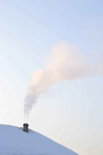 istock Smoke rises into the sky from an old chimney. 1087801974