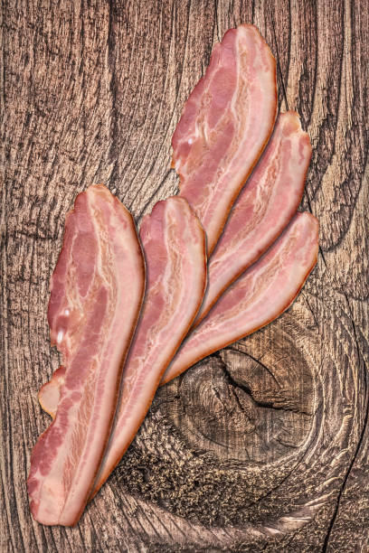 istock Three Pork Bacon Rashers Set On Old Knotted Weathered Cracked Pinewood Picnic Table Rustic Rough Grunge Surface 1087803724