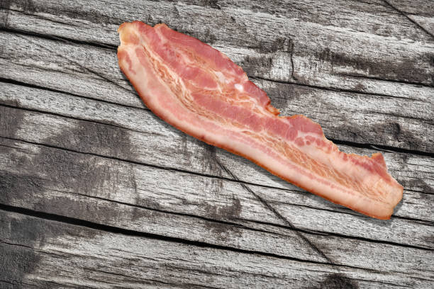 Single Pork Bacon Rasher On Old Knotted Weathered Cracked Pinewood Picnic Table Rustic Rough Grunge Surface