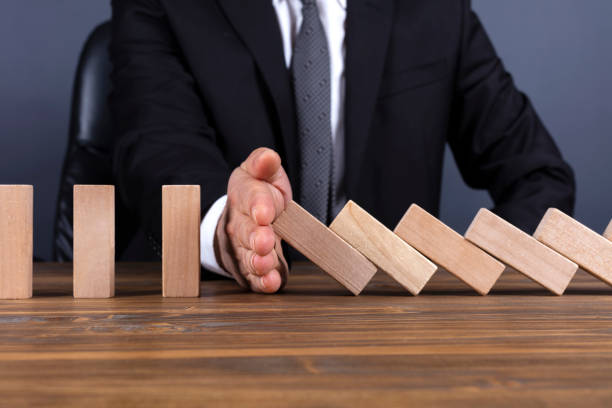 istock Businessman hand stop domino effect 1087810970