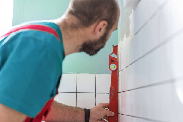 istock Tile mason leveling the bathroom wall 1087817538