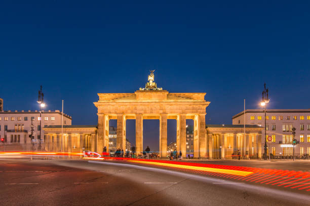 istock brandenburg gate at night with light effect of car drivers 1087823224