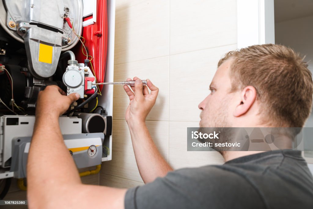 Technician repairing Gas Furnace Radiator - Heater Stock Photo