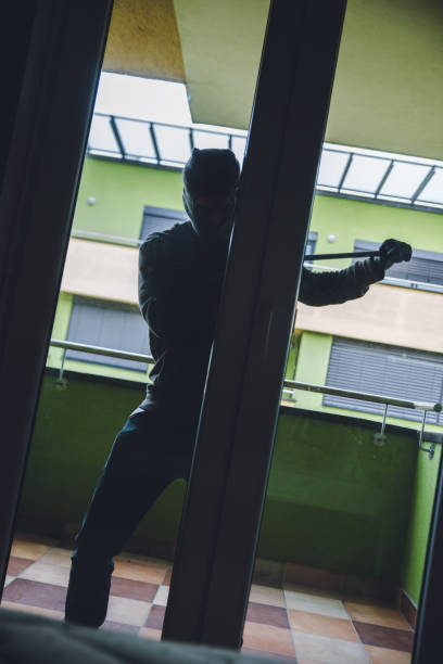 istock Burglar Breaking Into House 1087826336