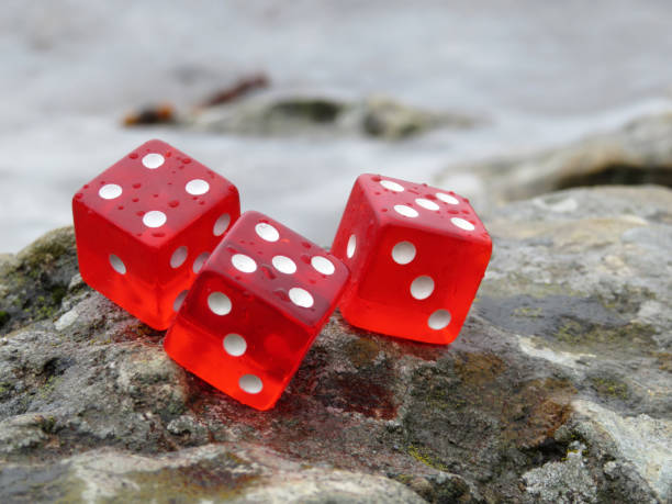 istock Red dice with water drops on the rocks in the seacoast 1087826362