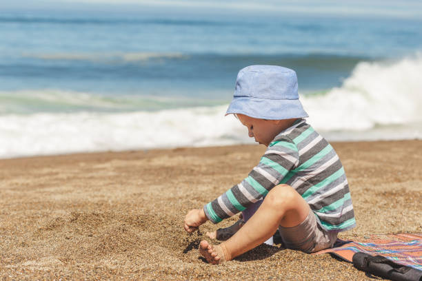istock Little boy with cute hat playing with sand 1087828044