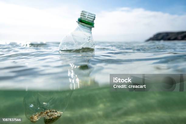 Used Plastic Water Bottle Floating On The Sea Surface Stock Photo - Download Image Now