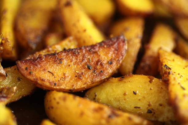 fried in ghee with spices pieces of potatoes stock photo