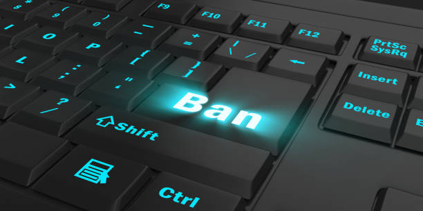 istock blue glowing Ban key on black keyboard 1087847504